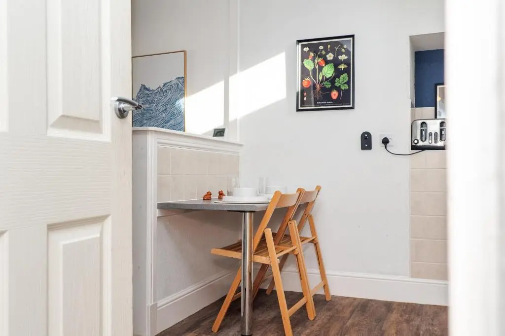 a small kitchen with a table and two chairs at Charming 1-Bed Coastal Cottage by Holiday Homes in Portgordon