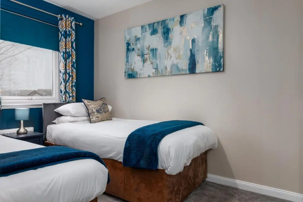 two beds in a room with blue and white walls at Castle Heather 2 Bedroom Holiday Home in Inshes