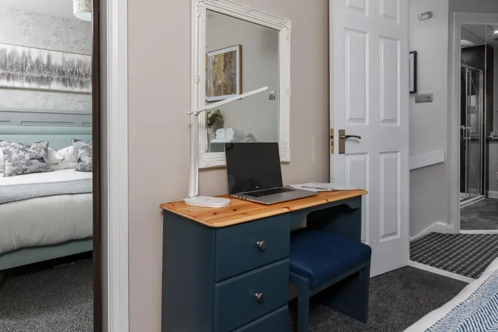a bedroom with a blue desk with a laptop on it at Castle Heather 2 Bedroom Holiday Home in Inshes