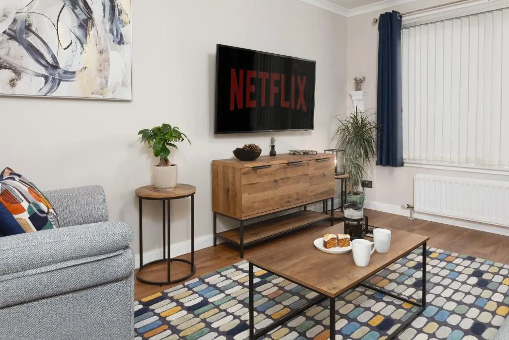 a living room with a couch and a tv at Castle Heather 2 Bedroom Holiday Home in Inshes