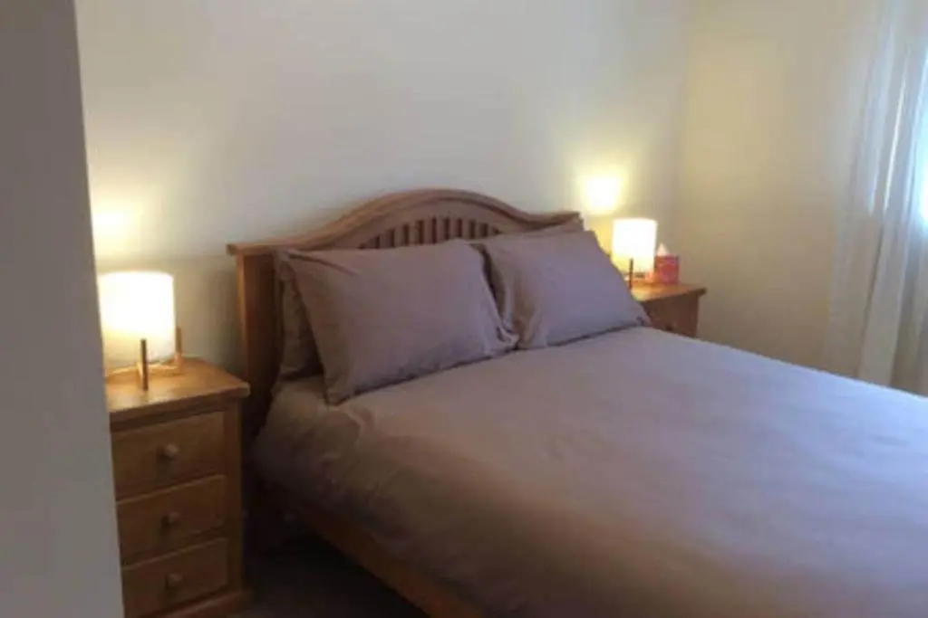 a bedroom with a bed with two nightstands and two lamps at Macdonald Apartment 11C Greig St Inverness IV3 5PT in Inverness