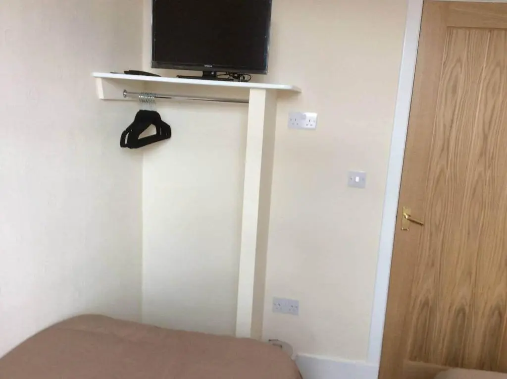 a room with a tv on top of a wall at Macdonald Apartment 11C Greig St Inverness IV3 5PT in Inverness