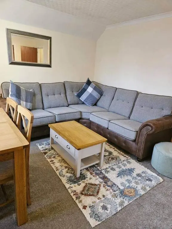 a living room with a couch and a table at 5 Ardross Court, 20 Ardross St. Inverness IV3 5NH in Inverness