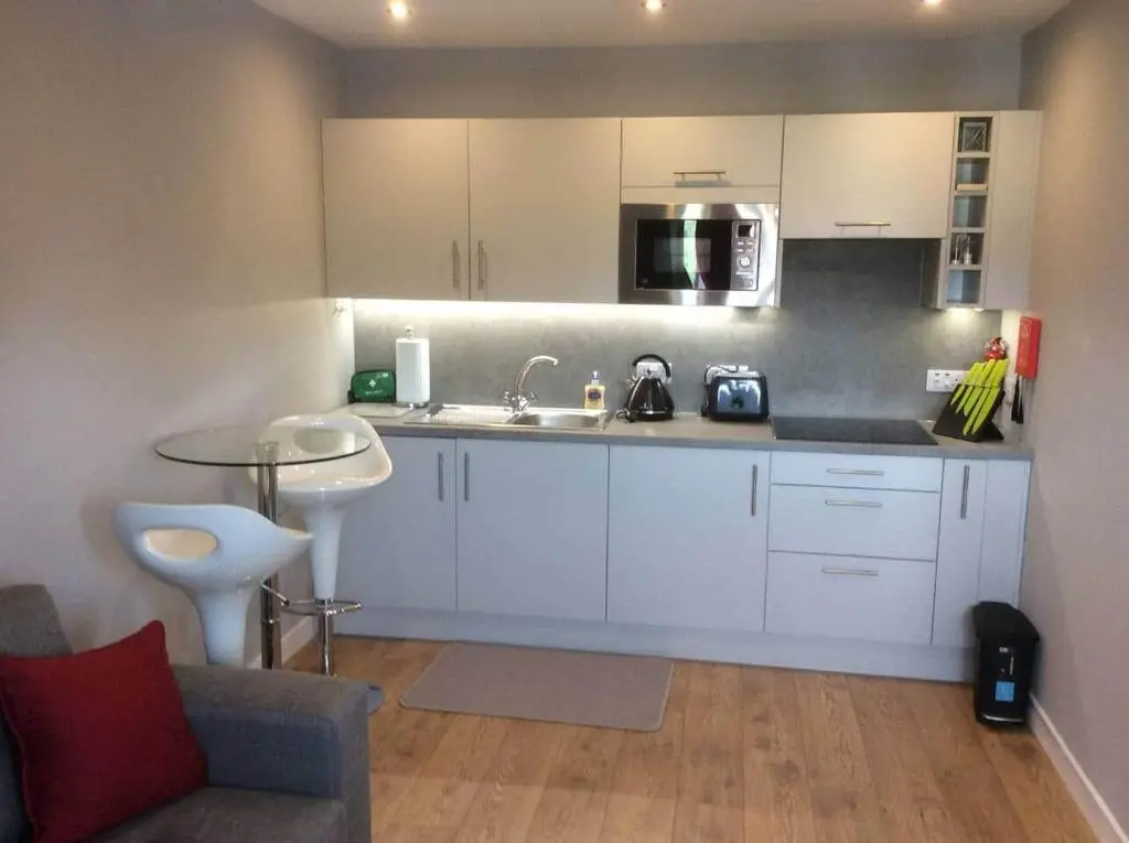 a kitchen with white cabinets and a sink at Flat 3/2 Murray Place Haugh Rd Inverness IV2 4SH in Inverness
