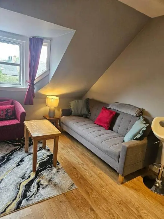 a living room with a couch and a table at Flat 3/2 Murray Place Haugh Rd Inverness IV2 4SH in Inverness