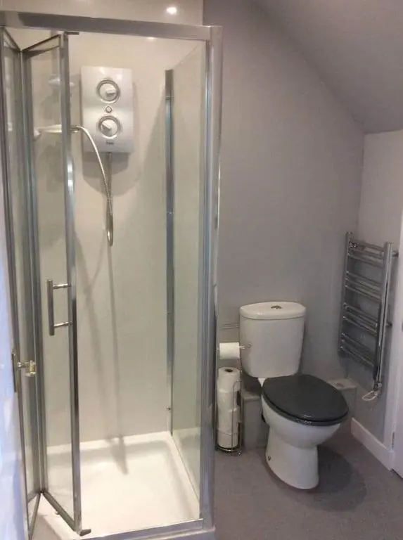 a bathroom with a toilet and a glass shower at Flat 3/2 Murray Place Haugh Rd Inverness IV2 4SH in Inverness