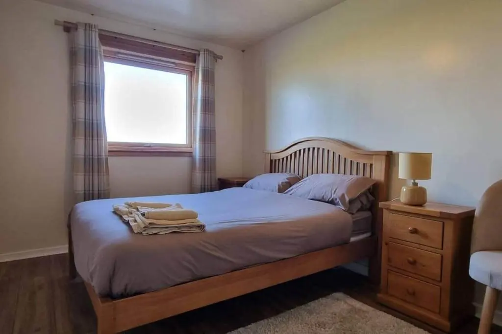 a bedroom with two beds and a window at Harbour View 45 Anderson Street Inverness IV3 8BU in Inverness