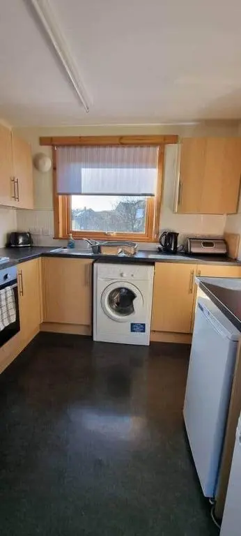 a kitchen with a washing machine and a window at Harbour View 45 Anderson Street Inverness IV3 8BU in Inverness
