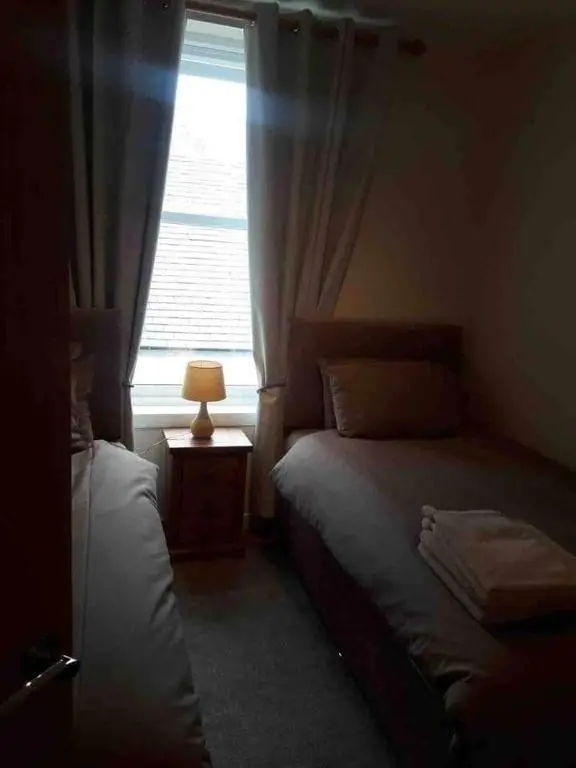 a bedroom with two beds and a window at Macdonald Apartments 9C Greig St Inverness IV3 5PT in Inverness