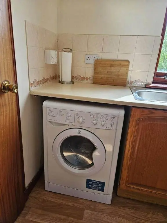 a kitchen with a washing machine under a counter at 8 Ardross Court 20 Ardross St. Inverness IV3 5NH in Inverness