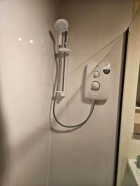 a shower in a bathroom with a shower head at 8 Ardross Court 20 Ardross St. Inverness IV3 5NH in Inverness