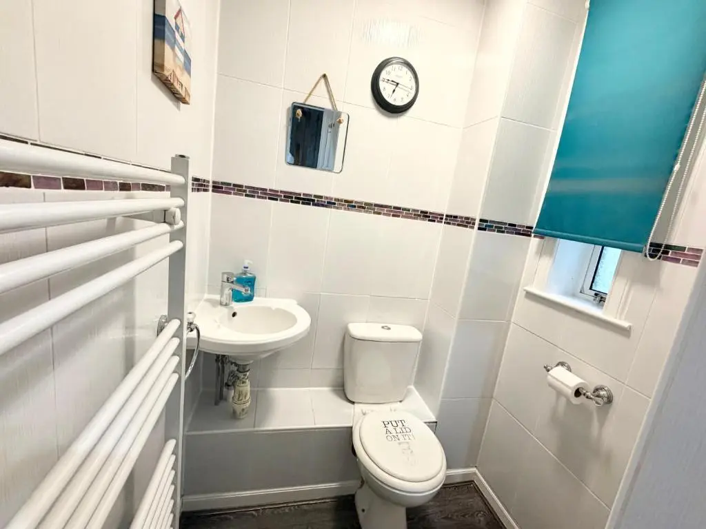 a small bathroom with a toilet and a sink at Mamore House Inverness in Dalneigh