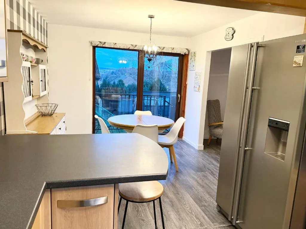 a kitchen with a table and a dining room at Mamore House Inverness in Dalneigh