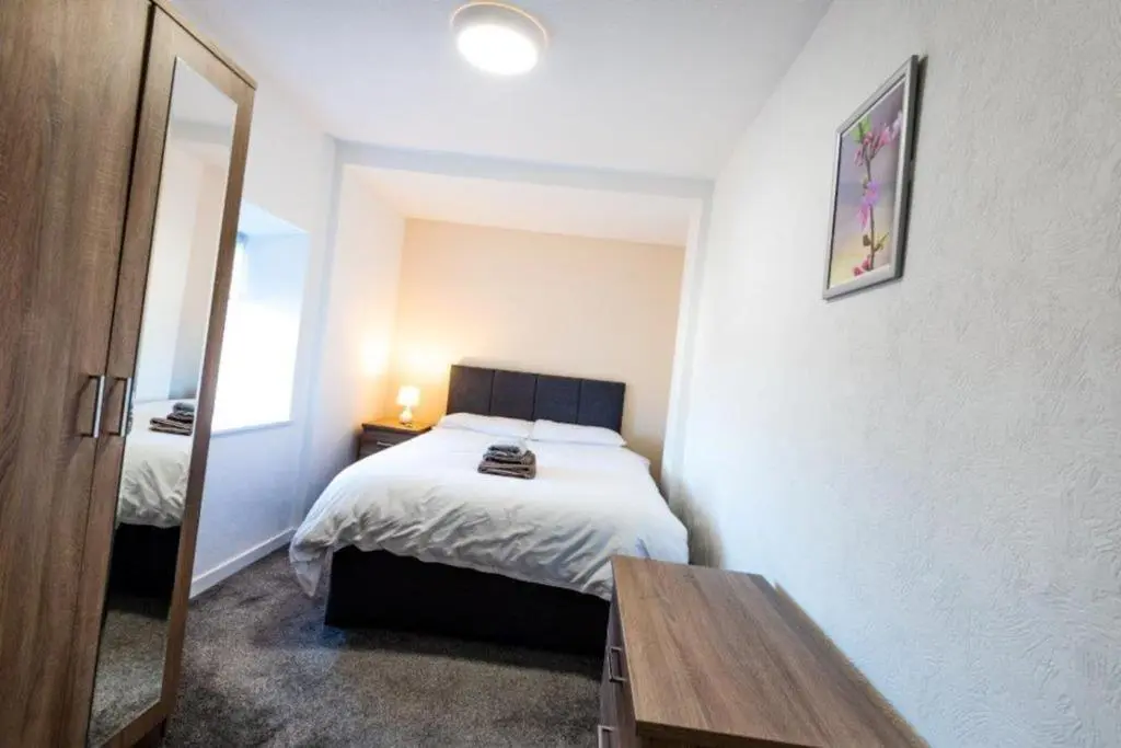 a small bedroom with a bed and a mirror at Josies House in Banff
