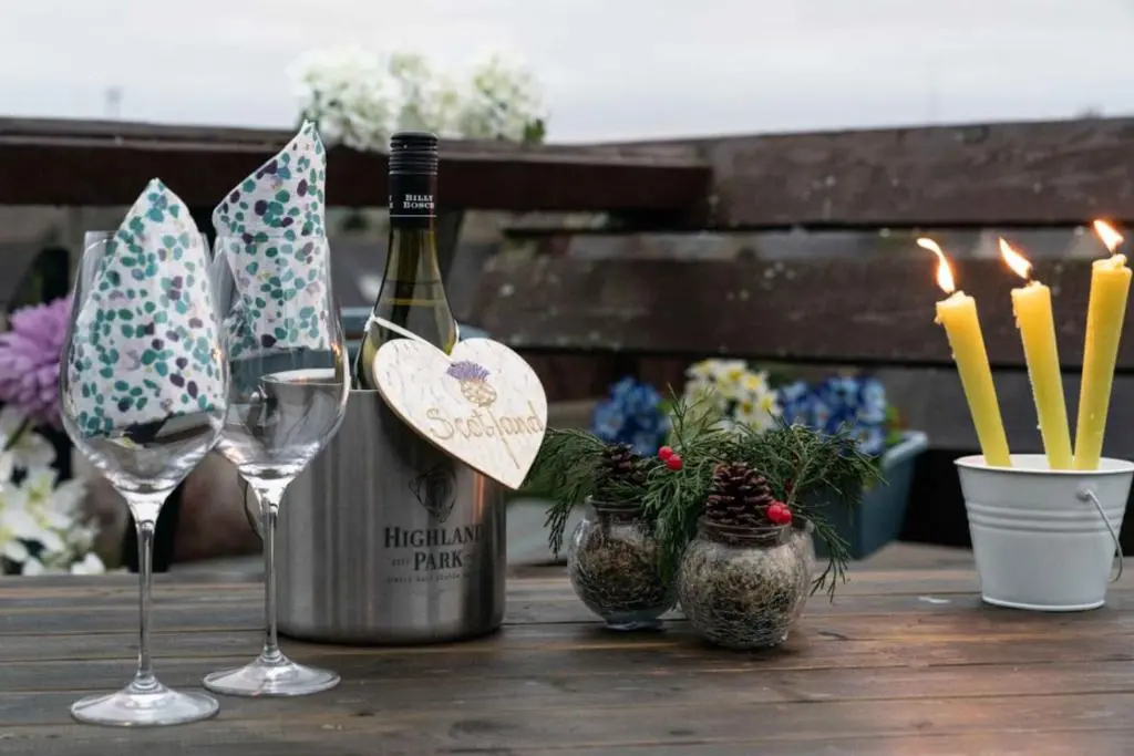 a bottle of wine and two glasses on a table at Dunedin House in Huntly