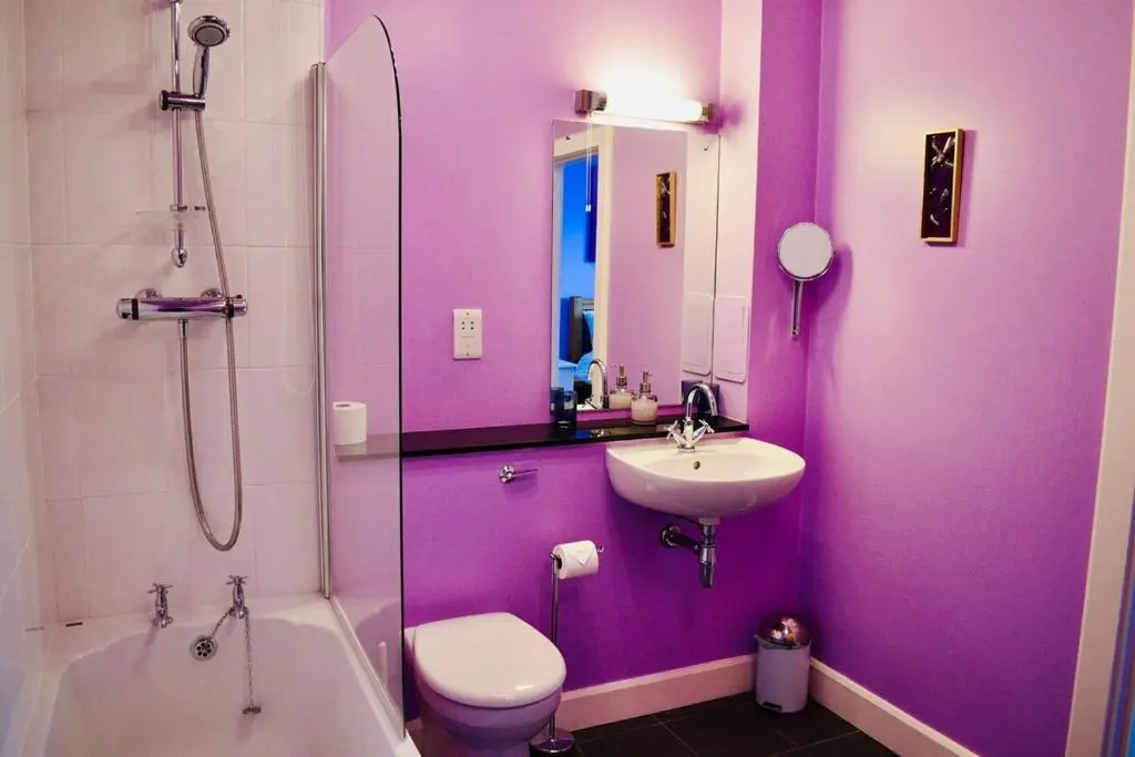 a purple bathroom with a toilet and a sink at Entirely New Monastery Renovation on Loch Ness in Fort Augustus