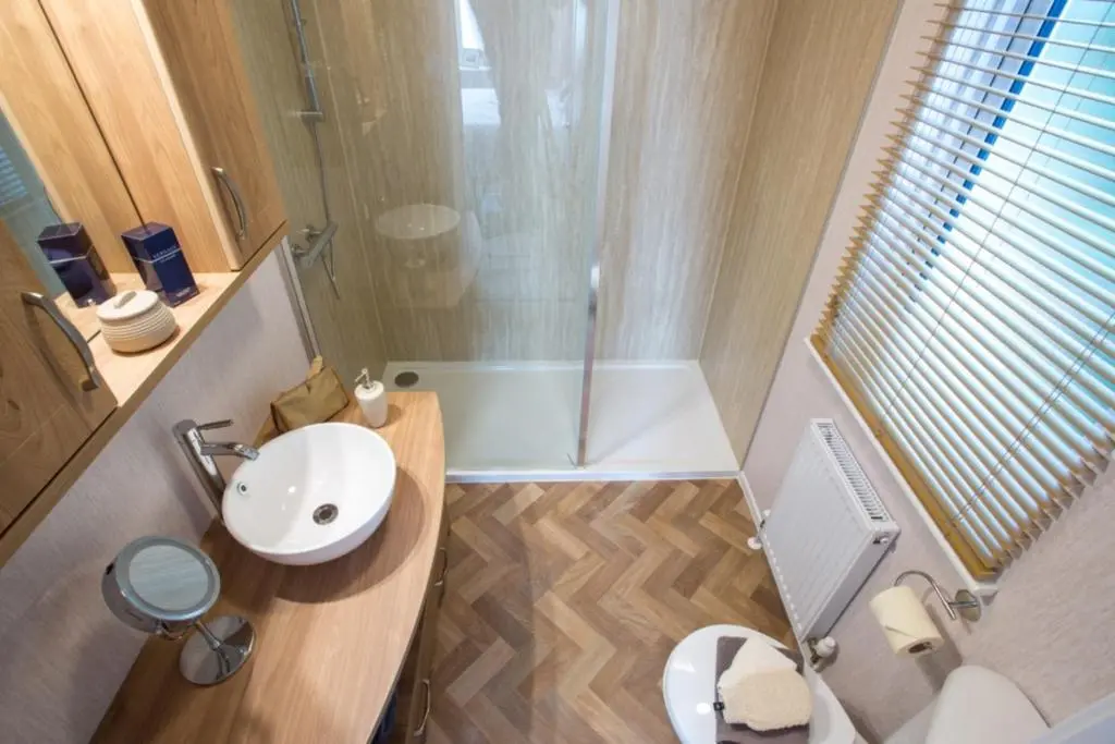 a small bathroom with a sink and a shower at Lyndale Lodge