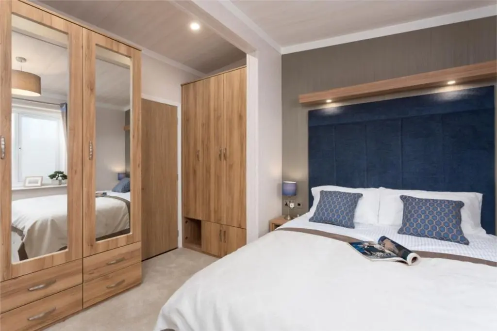 a bedroom with a large bed with a blue wall at Lyndale Lodge