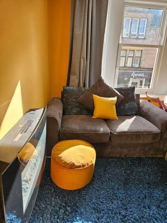 a living room with a couch and a table at City center apartment in Inverness
