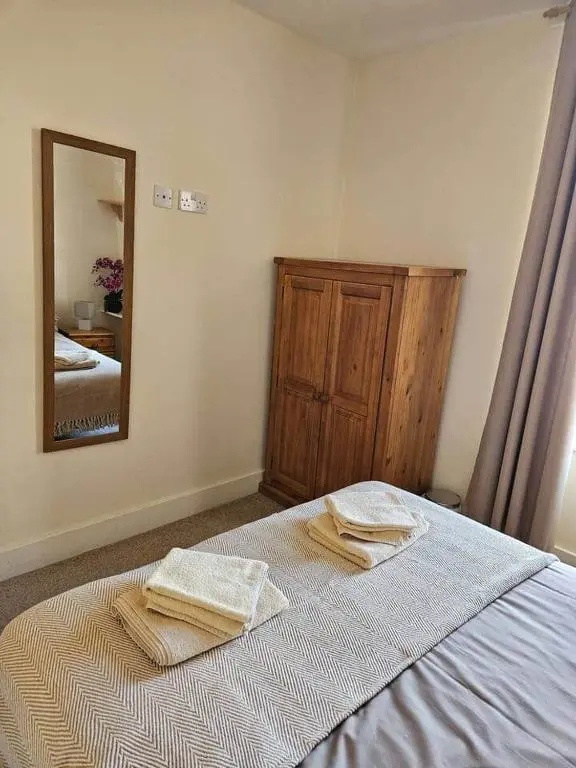 a bedroom with a bed with two towels on it at City center apartment in Inverness
