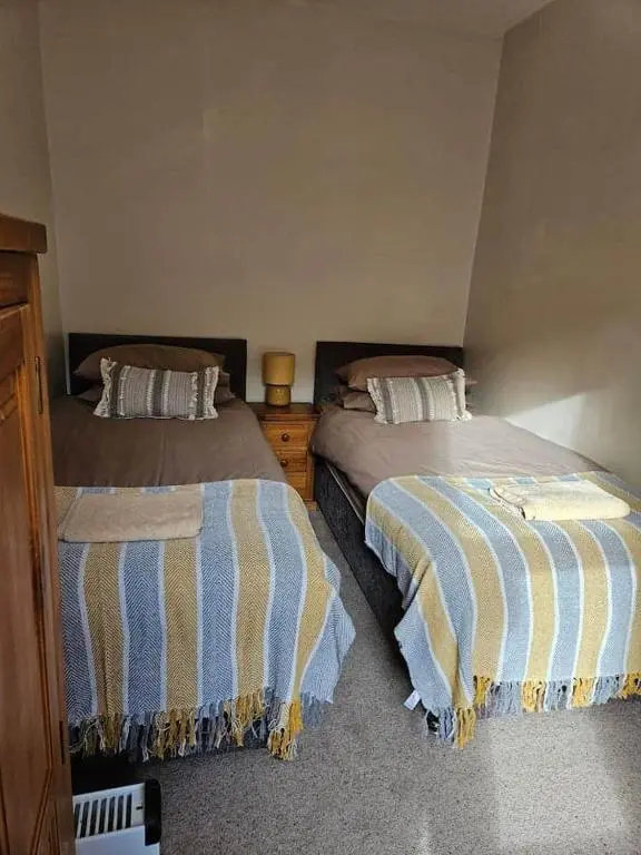 two beds sitting next to each other in a bedroom at City center apartment in Inverness