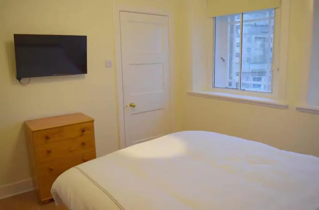 a bedroom with a bed and a television on the wall at Bankside - 1 En-Suite in Central - Free Parking in Wick