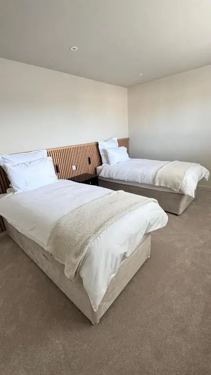 two beds in a room with white walls at No 67 West Road in Fraserburgh