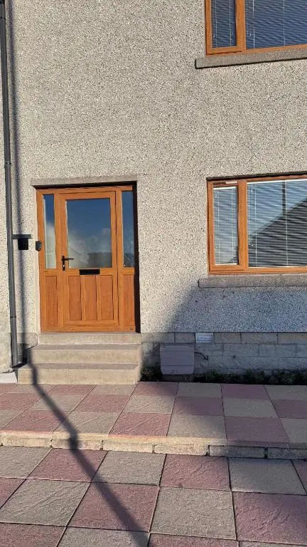 a building with a wooden door and two windows at No 67 West Road in Fraserburgh