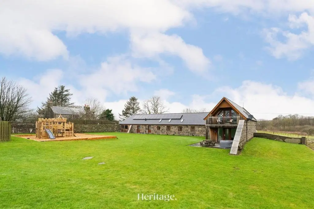 a large yard with a building and a playground at The Steading Family Friendly Getaway in Peterhead