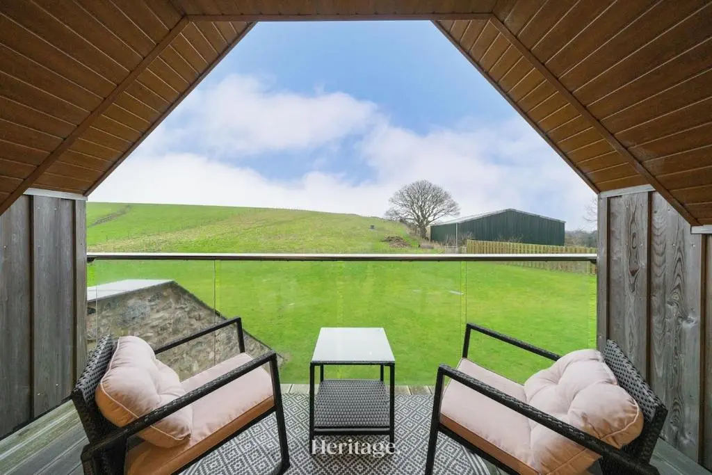 a screened in porch with two chairs and a table at The Steading Family Friendly Getaway in Peterhead