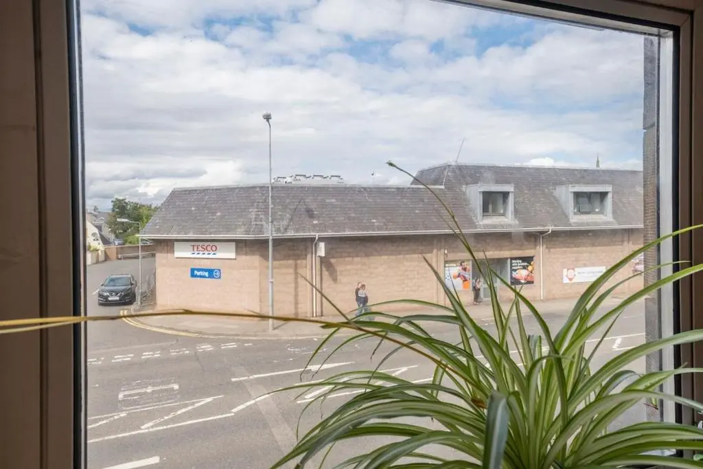 a window with a view of a parking lot at 2 Bed Central Apart - May Court in Inverness