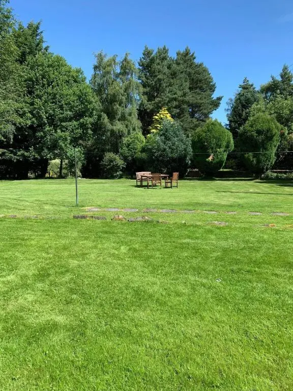a park with two picnic tables in the grass at Freeburn Lodge - Tomatin in Tomatin