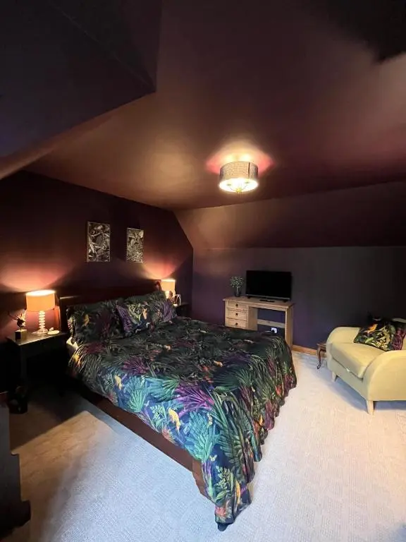 a bedroom with a bed and two tables and two lamps at Freeburn Lodge - Tomatin in Tomatin