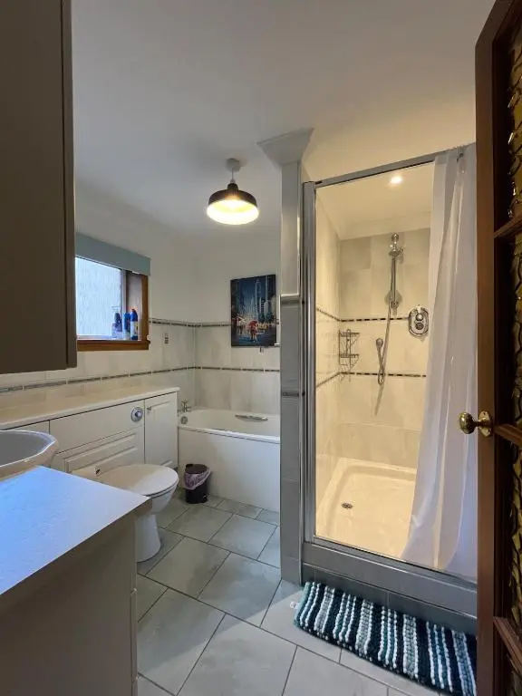 a bathroom with a shower and a toilet at Freeburn Lodge - Tomatin in Tomatin