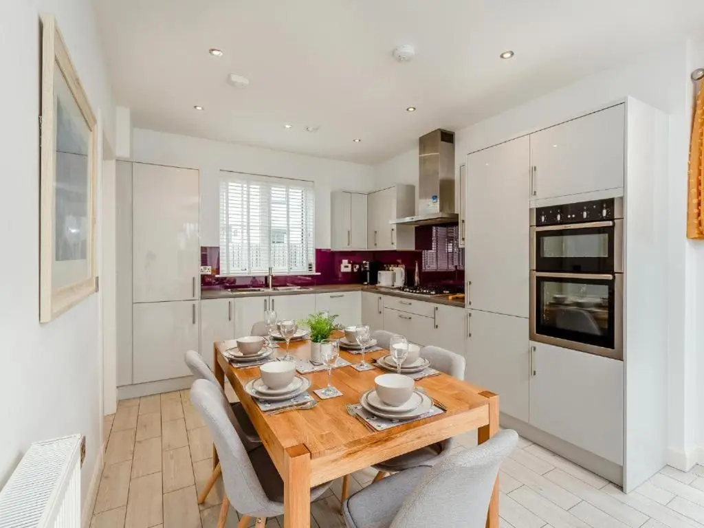 a dining room with a wooden table and chairs in a kitchen at One The Loan in Inverness