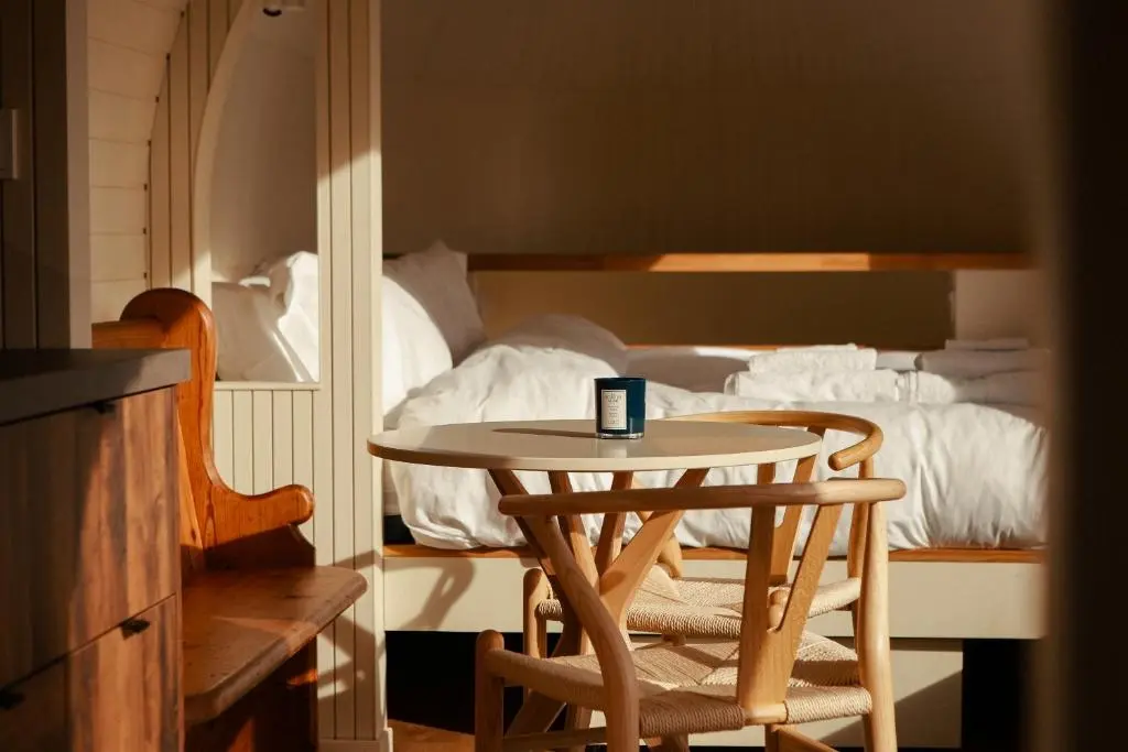 a table and two chairs in front of a bed at Boath Cabin in Auldearn