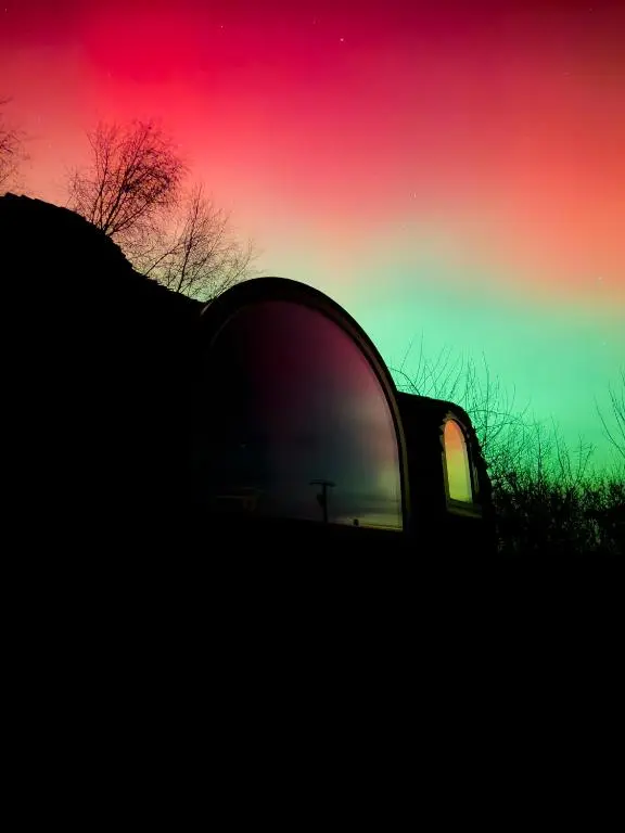 a reflection of a car with the sunset in the side view mirror at Boath Cabin in Auldearn