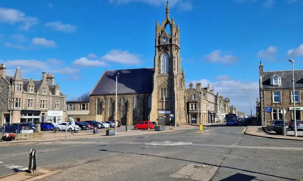 an old church with a clock tower on a street at Buckie Central 2 Bed Retreat in Buckie
