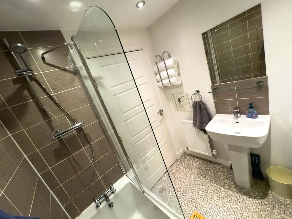 a bathroom with a shower and a sink at Skibo Place House in Inshes