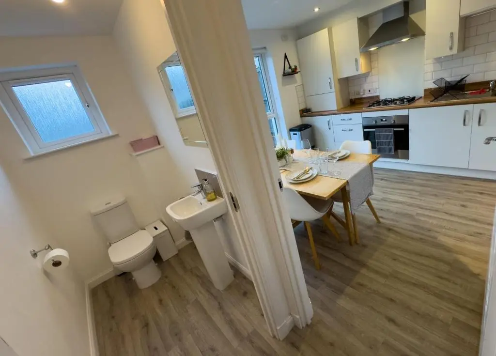 a bathroom with a sink and a toilet and a table at Skibo Place House in Inshes