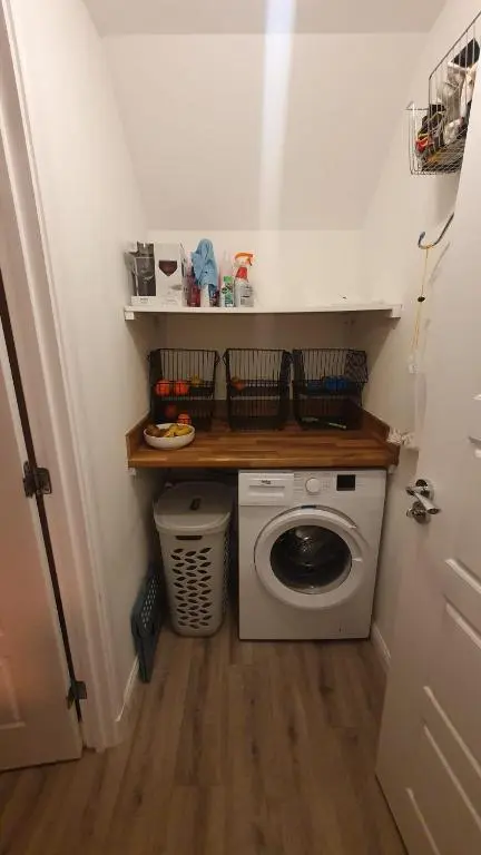 a small laundry room with a washing machine in it at Skibo Place House in Inshes