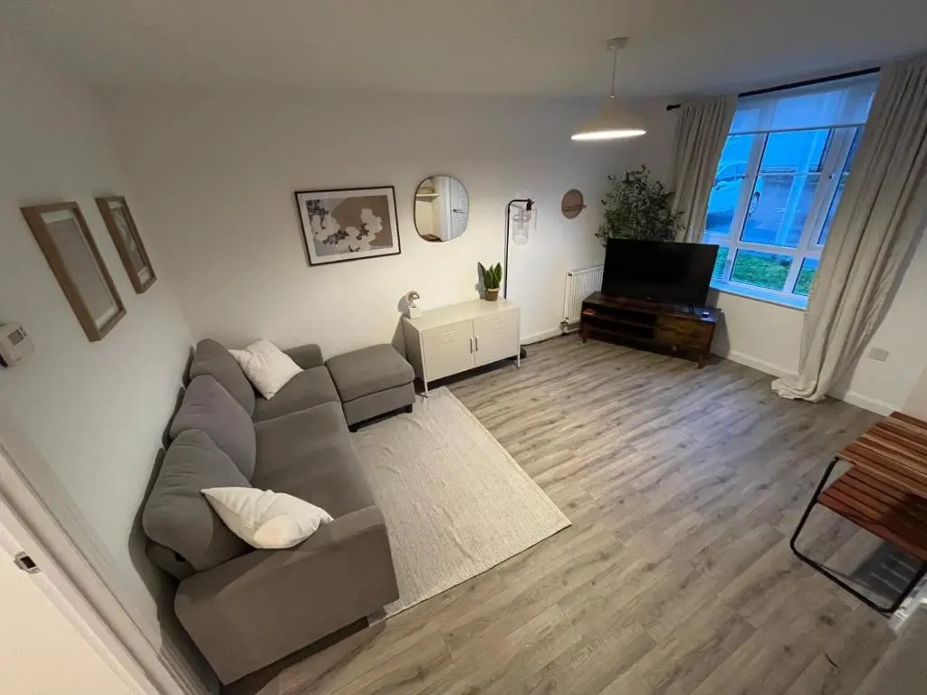 a living room with a couch and a television at Skibo Place House in Inshes