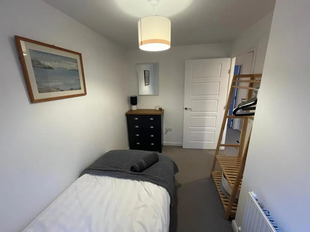 a small bedroom with a bed and a staircase at Skibo Place House in Inshes