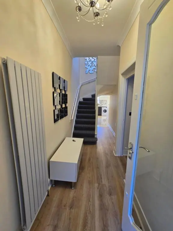 a hallway with stairs and a chandelier at Nanny bambi's three bedroom's in Inverness