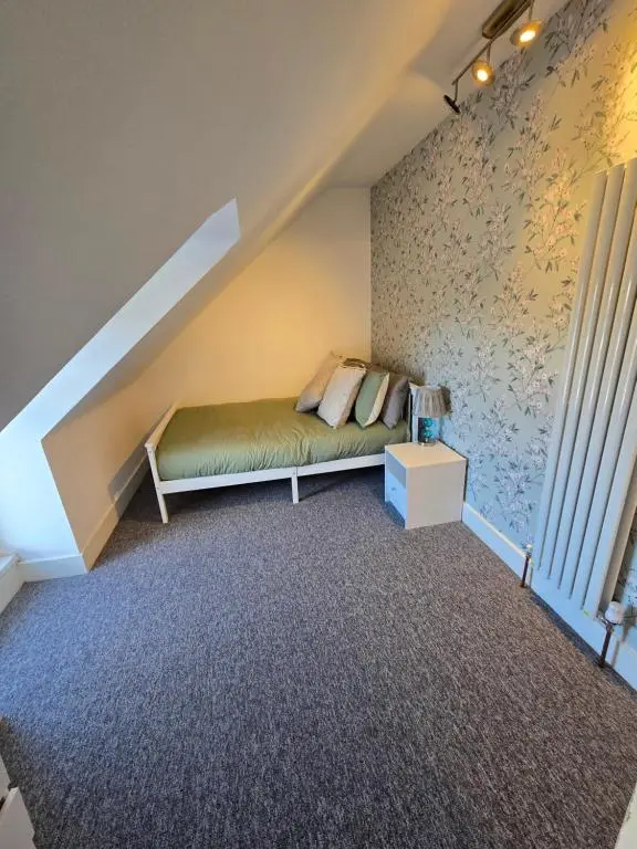 a bedroom with a bed in the corner of a room at Nanny bambi's three bedroom's in Inverness