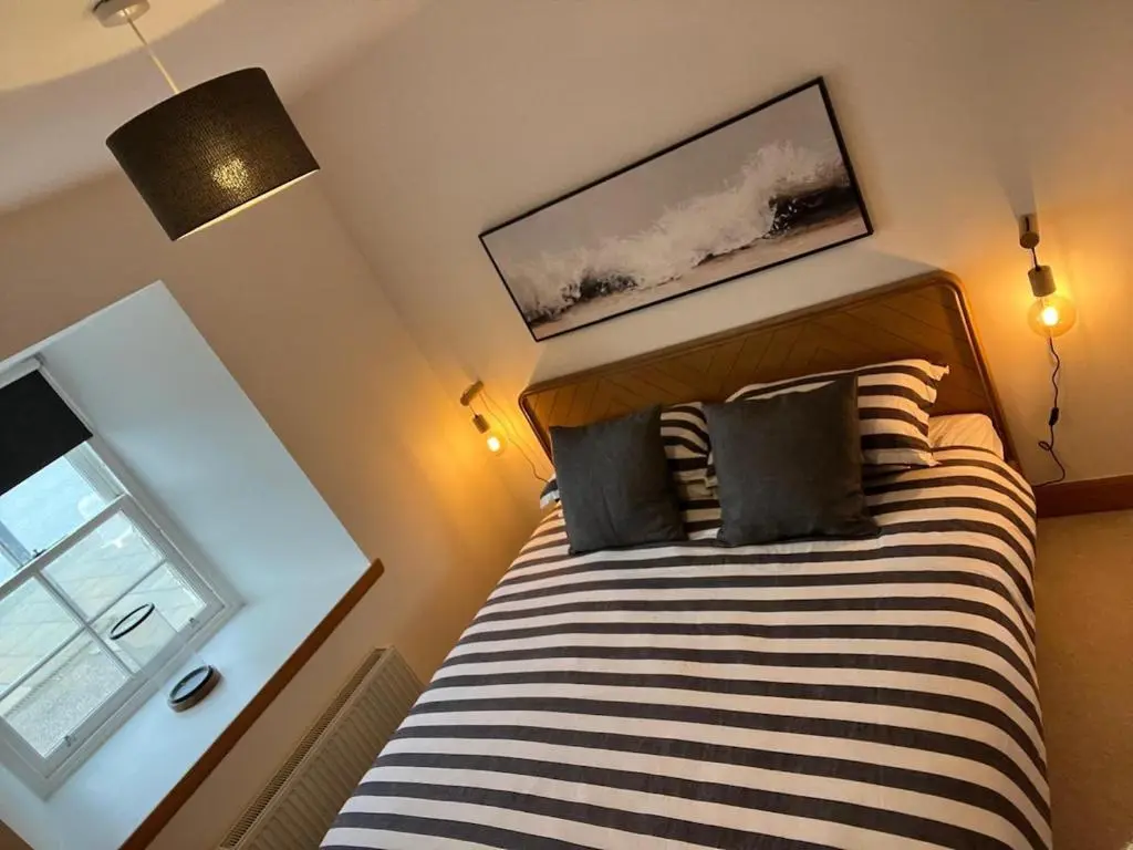a bedroom with a bed and a window at Harbour Haven in Burghead