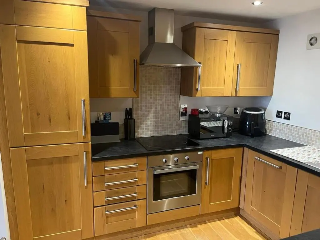 a kitchen with wooden cabinets and a stove top oven at Harbour Haven in Burghead