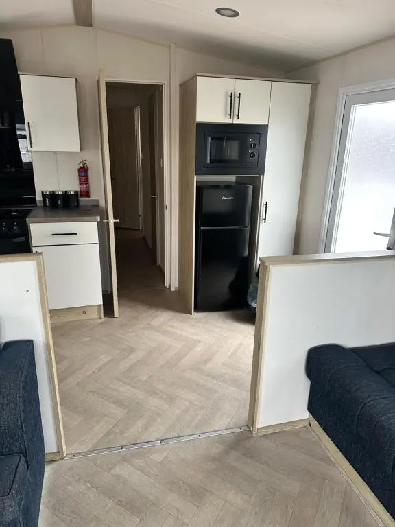 a living room with a kitchen with a mirror at Moonstone in Lossiemouth