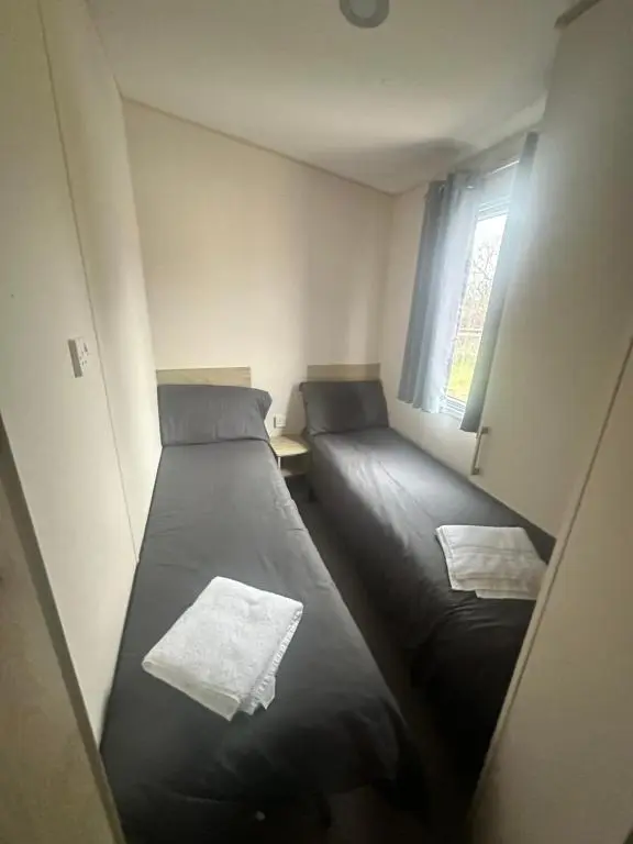 two beds in a small room with a window at Moonstone in Lossiemouth