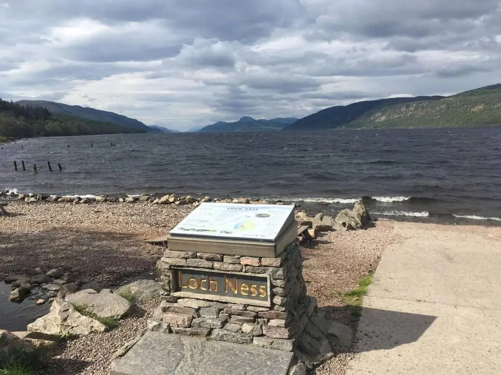 a sign on the shore of a body of water at Cosy flat in Inverness